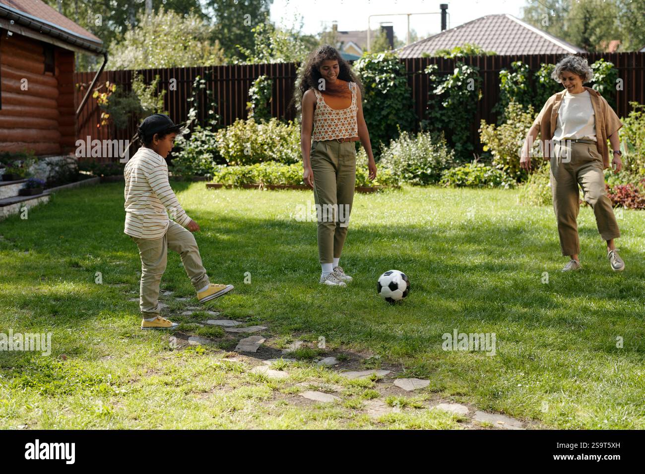 Playing Soccer Outdoor in Green Backyard Setting Stock Photo