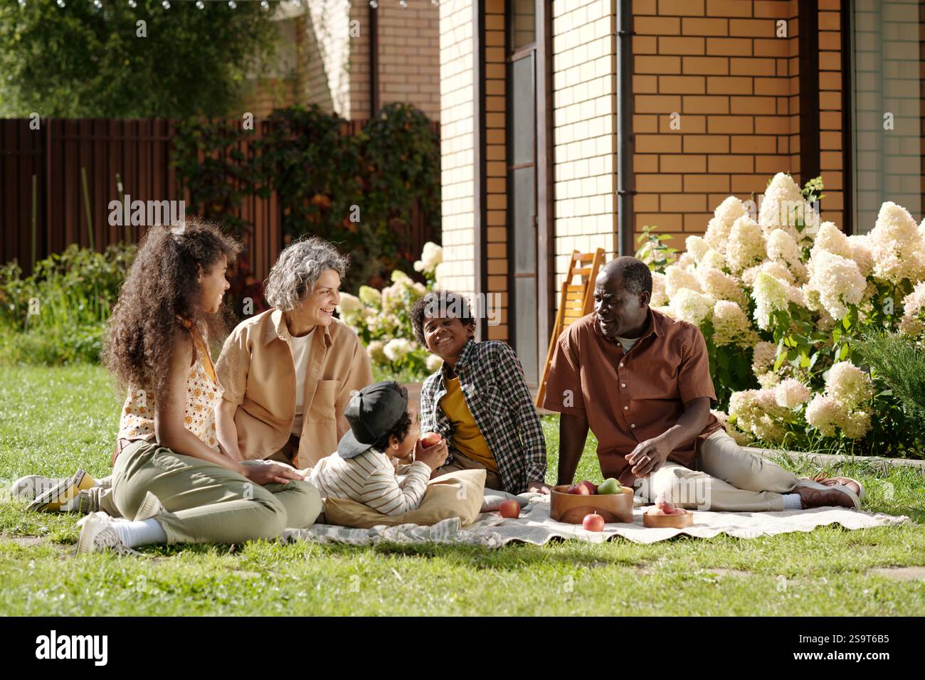 Enjoying Picnic Outdoors With Family Under Sunlight Stock Photo