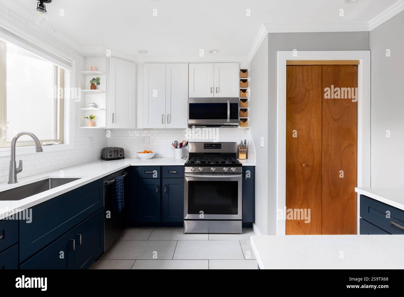 A kitchen detail with white and blue cabinets, large format white ...