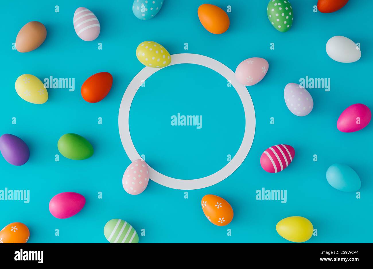 Colorful pattern composition made of various colored Easter eggs on light blue background with copy space. Minimal Easter concept. Stock Photo