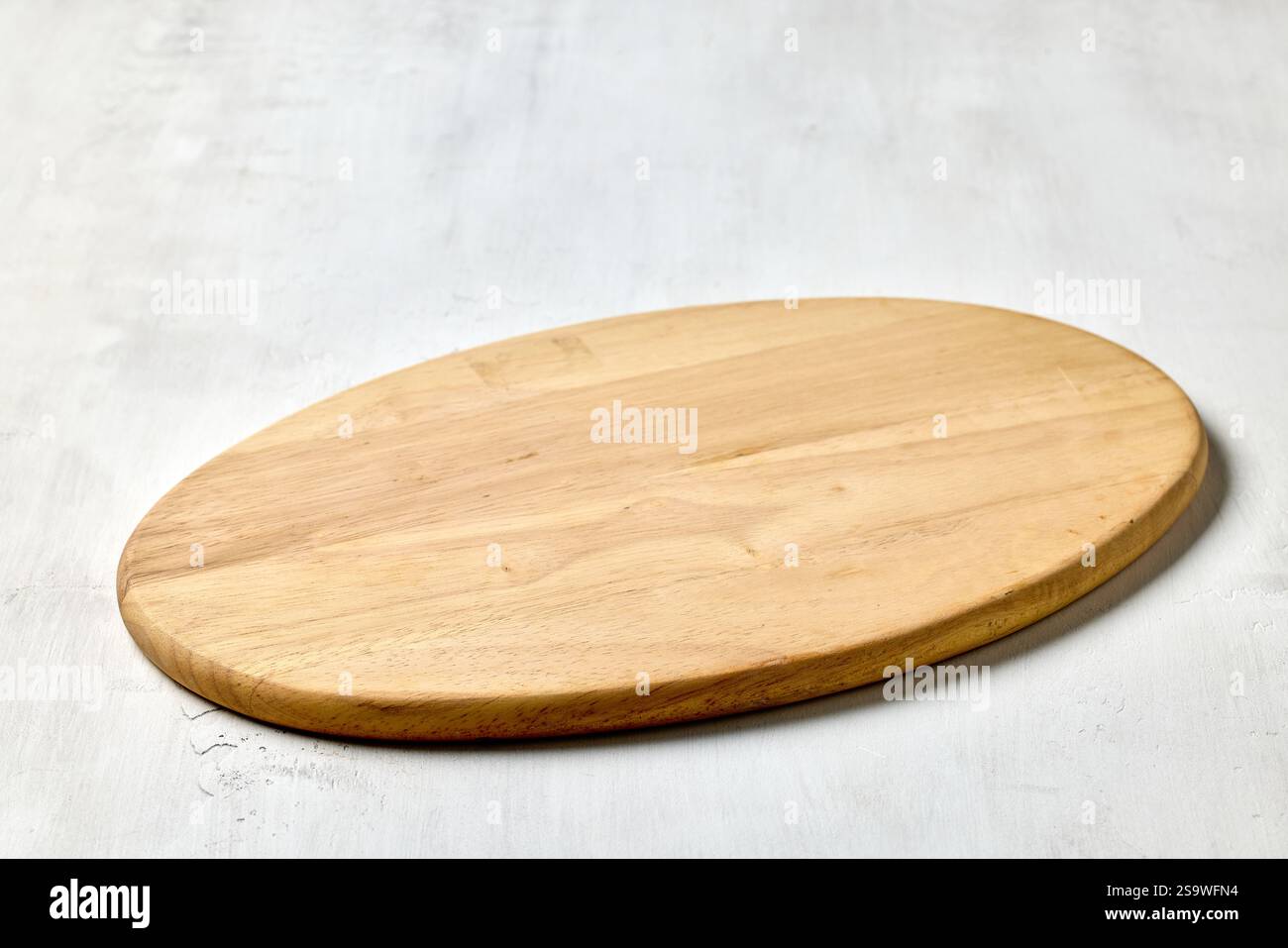 empty clean wooden cutting board on white kitchen table background Stock Photo