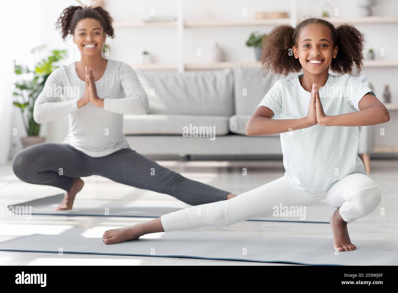Sporty black family mother and daughter exercising at home Stock Photo ...