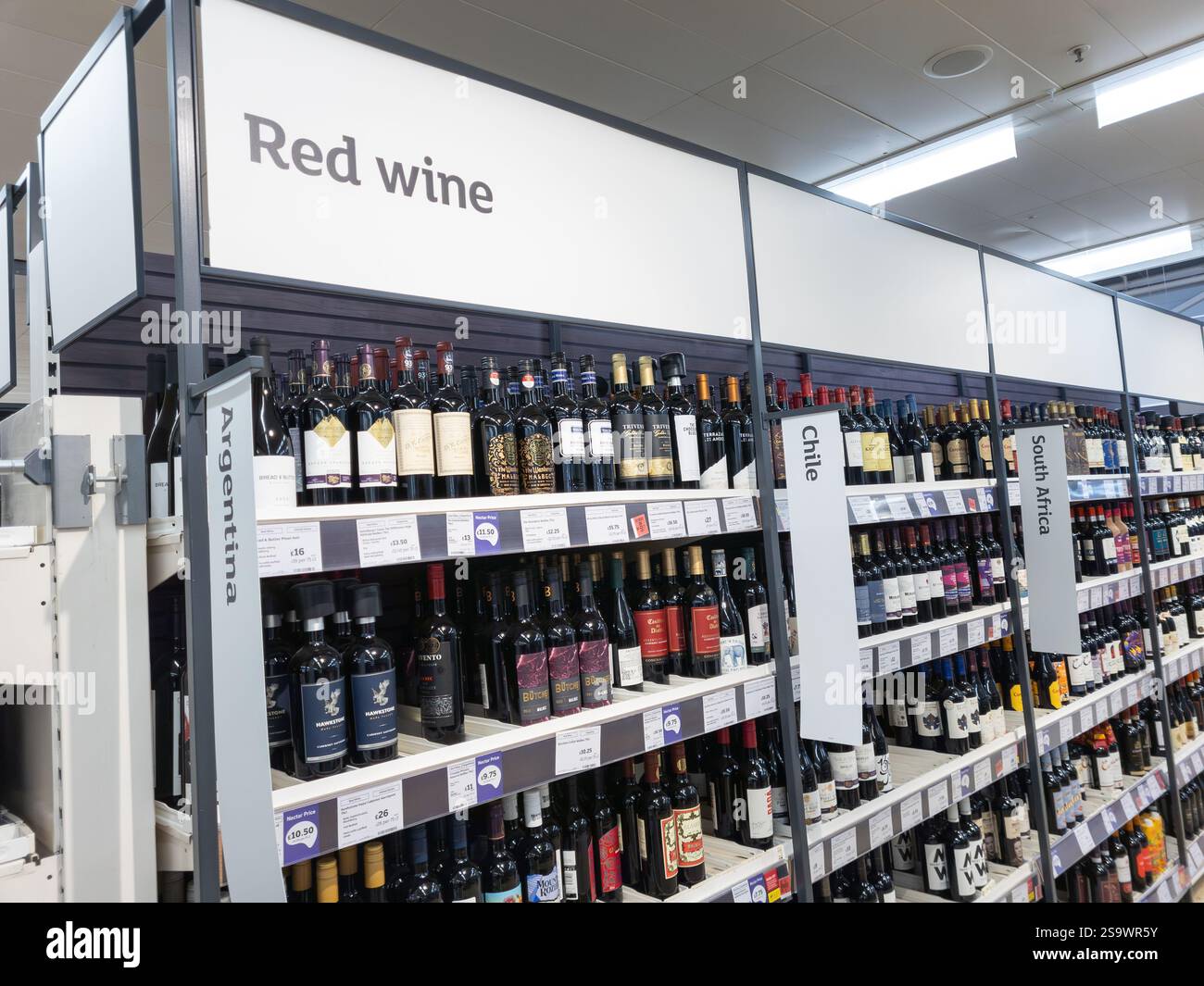 Red wine aisle in a Sainsbury's supermarket, with wine bottles from different countries, UK. Concept: cost of living, alcohol sales, theft - Smartphone Captured Stock Image