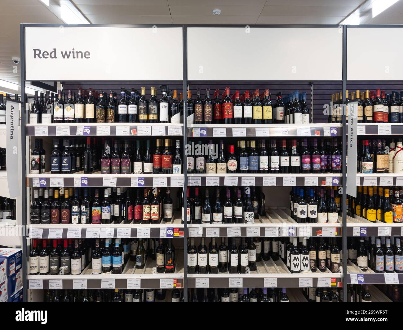 Red wine aisle in a Sainsbury's supermarket, with wine bottles from different countries, UK. Concept: cost of living, alcohol sales, theft - Smartphone Captured Stock Image