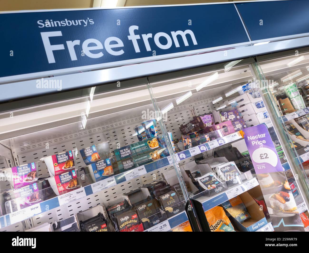 Free From aisle with gluten free food in fridges at a Sainsbury's supermarket, UK. A gluten free diet can help with Celiac (Coeliac) disease - Smartphone Captured Stock Image
