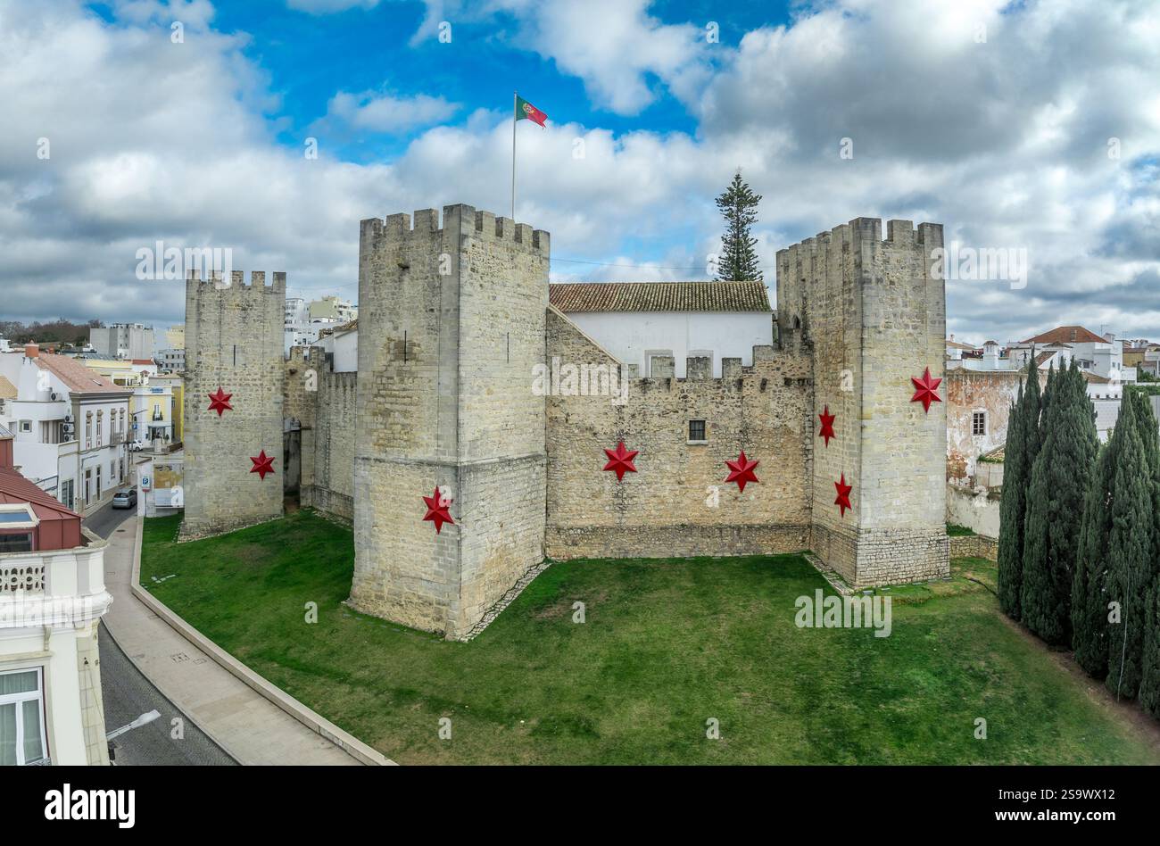 Aerial view of Loule castle in Algarve Portugal, three outward projecting square towers with Christmas star decoration and Portuguese flag Stock Photo