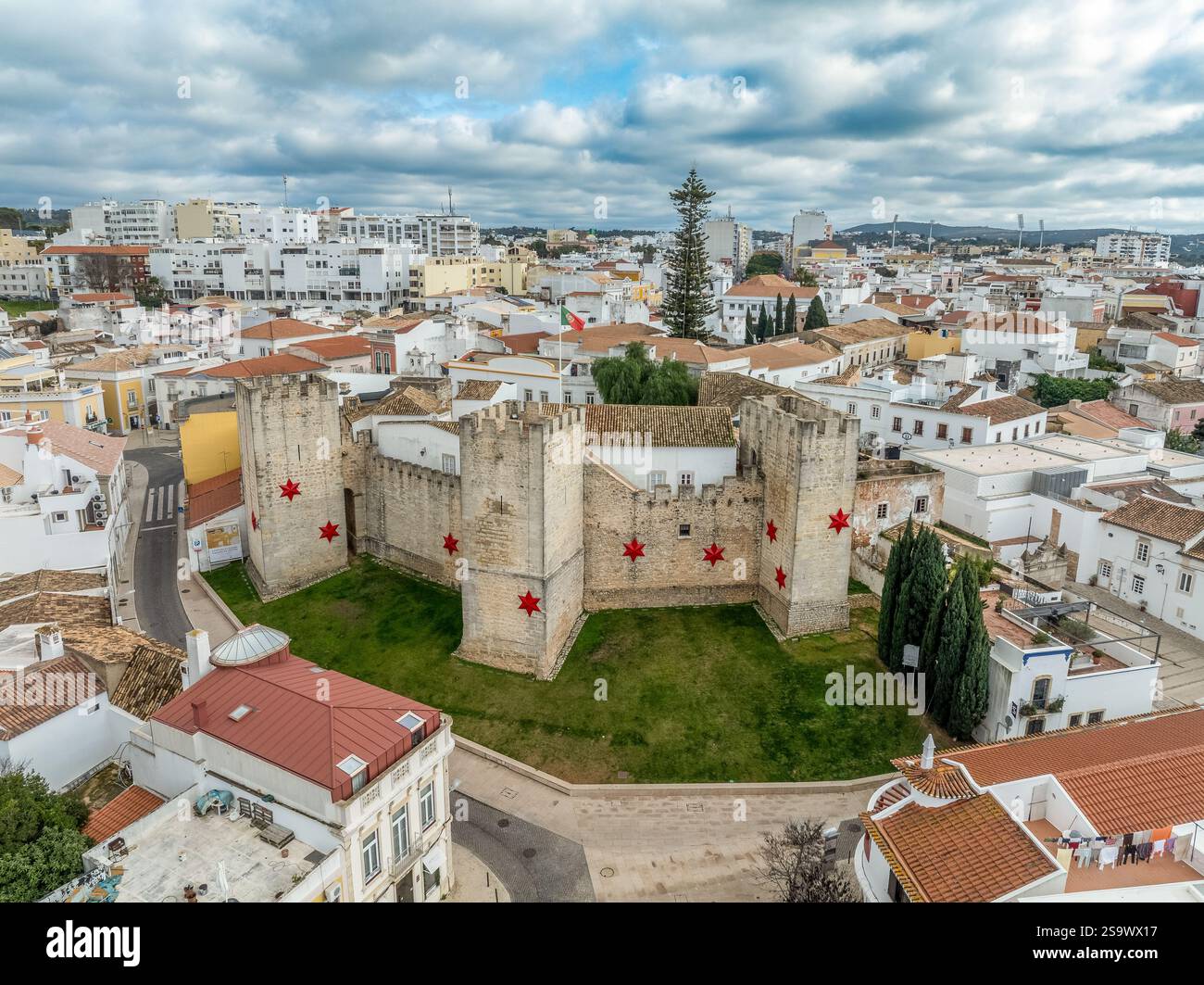 Aerial view of Loule castle in Algarve Portugal, three outward projecting square towers with Christmas star decoration and Portuguese flag Stock Photo