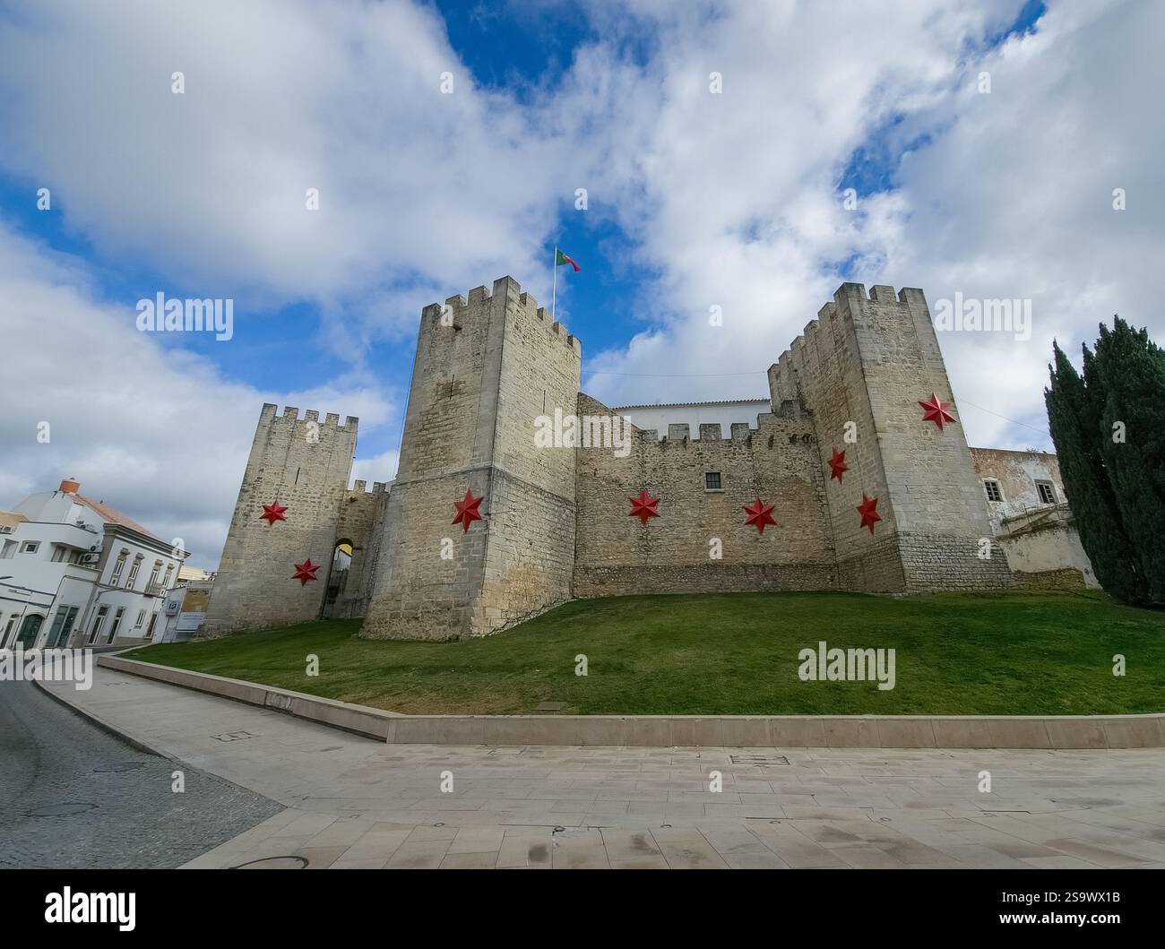 Aerial view of Loule castle in Algarve Portugal, three outward projecting square towers with Christmas star decoration and Portuguese flag Stock Photo