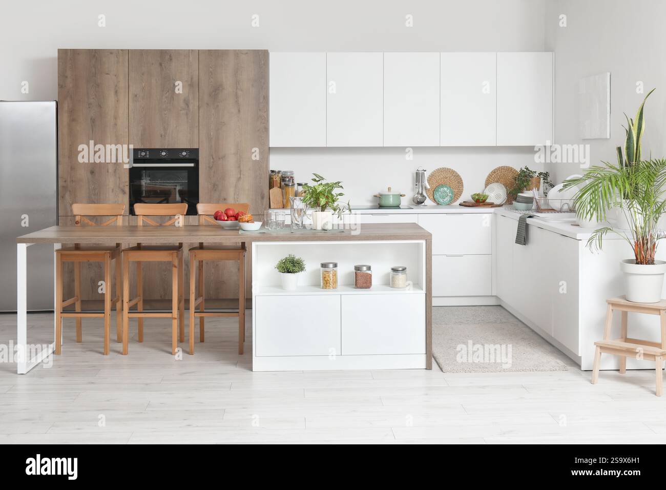 Interior of modern kitchen with island table and white counters Stock ...