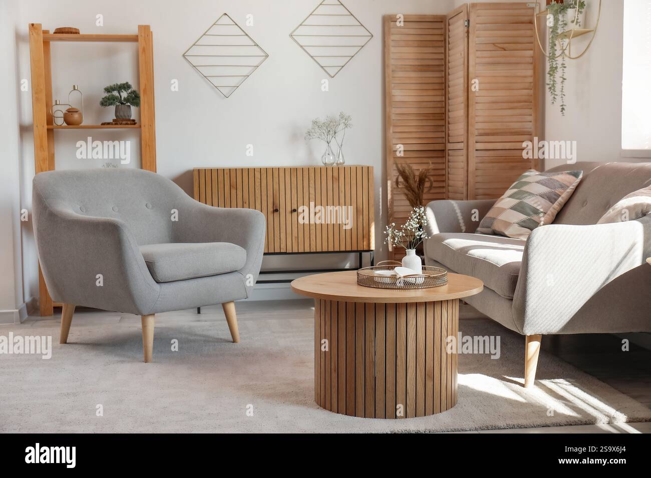 Interior of stylish living room with sofa, armchair, table and candle ...