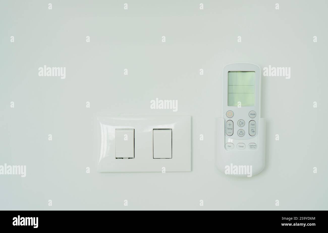 White electric switch and air conditioner remote control on the white ...