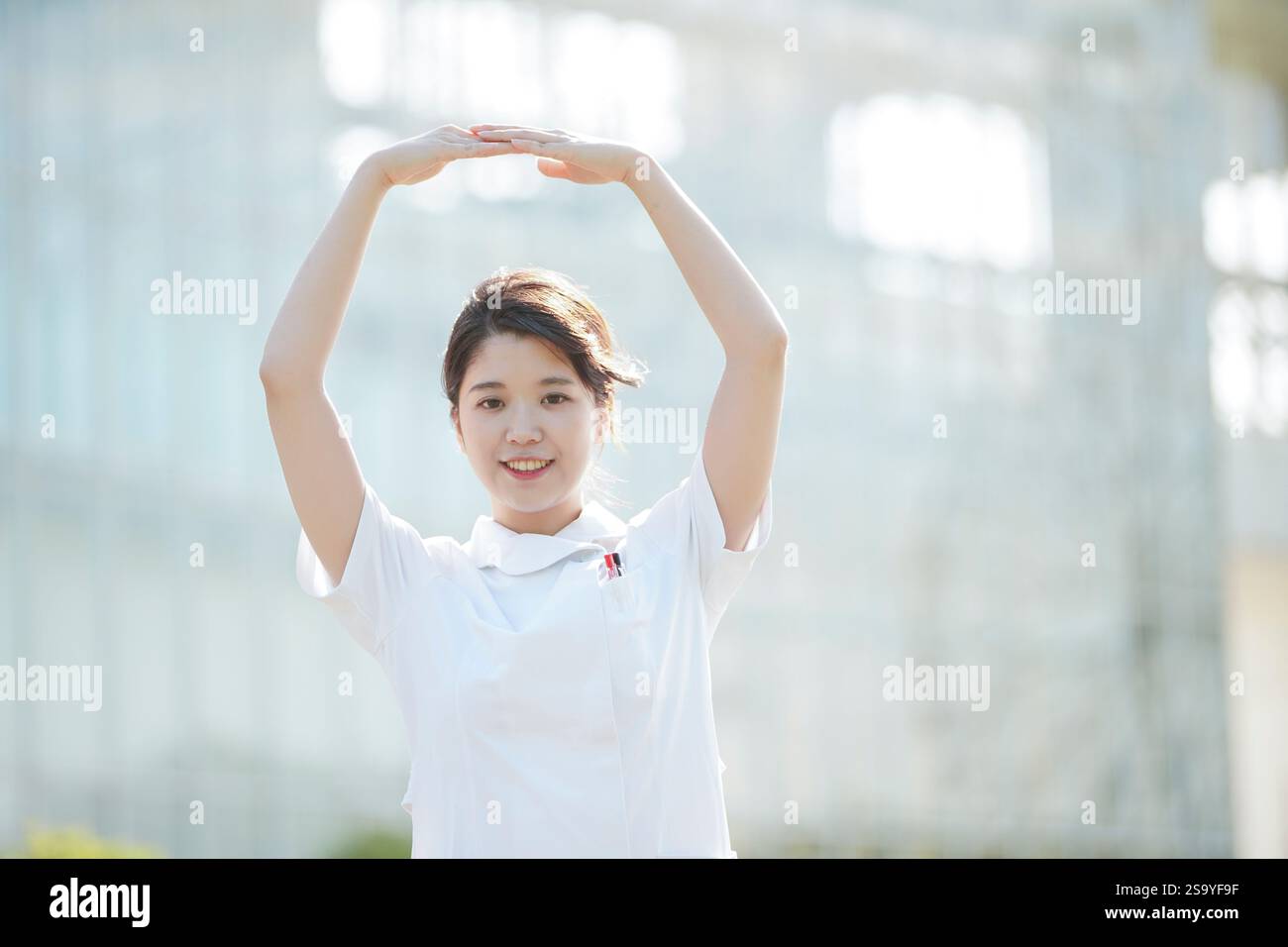 Woman in white making the ‘Maru’ sign Stock Photo - Alamy