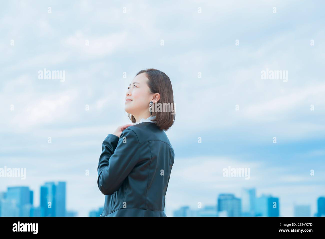 Casually dressed asian business woman looking up at the sky Stock Photo ...