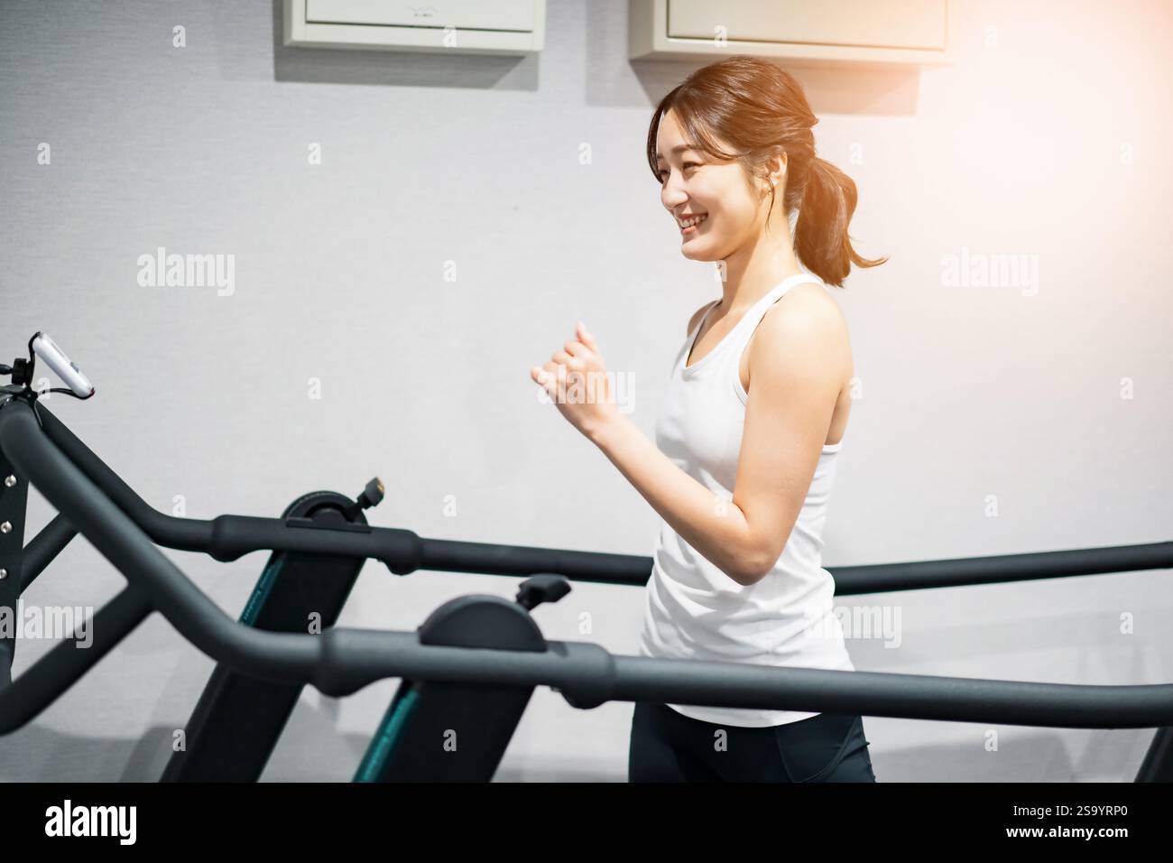 Woman exercising on running machine Stock Photo - Alamy