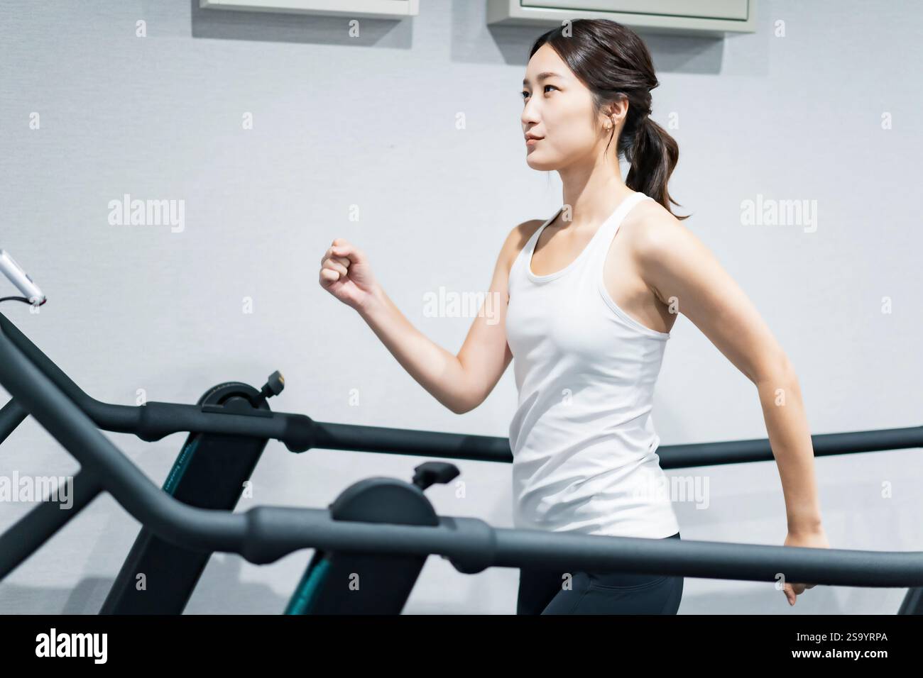 Woman exercising on running machine Stock Photo - Alamy