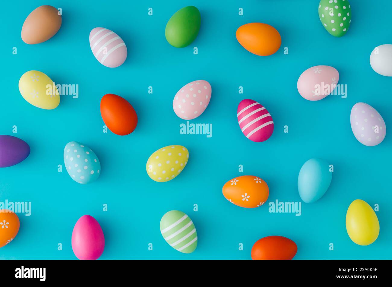 Colorful pattern composition made of various colored Easter eggs on light blue background. Minimal Easter concept. Stock Photo