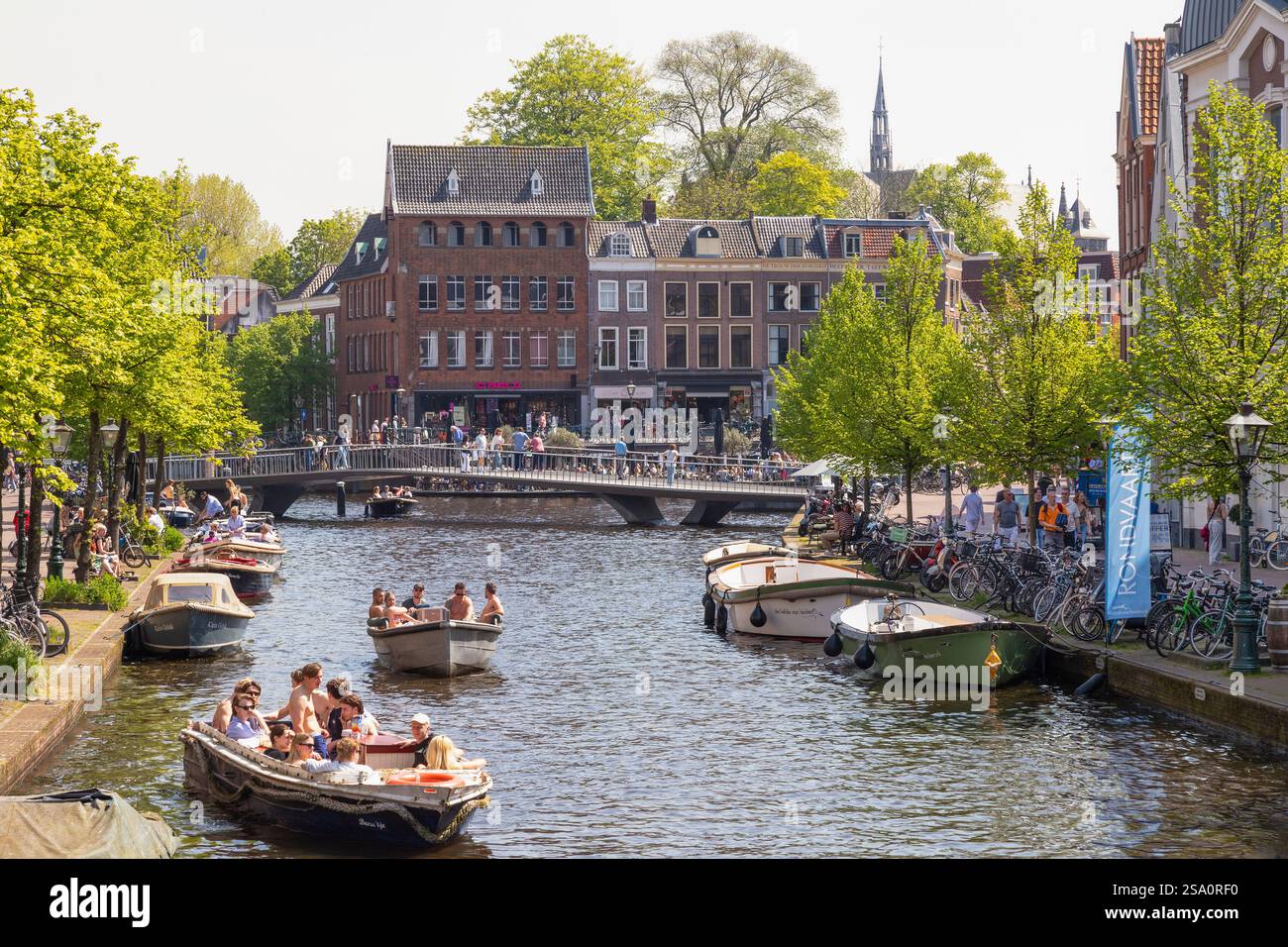 Students sail on the canals in the city center of Leiden on a beautiful sunny day. Stock Photo