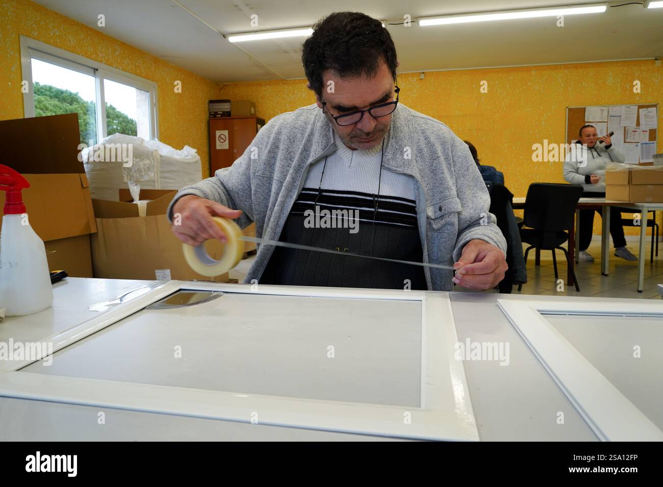 Disabled worker working in the shaping and packaging workshop. Quality ...