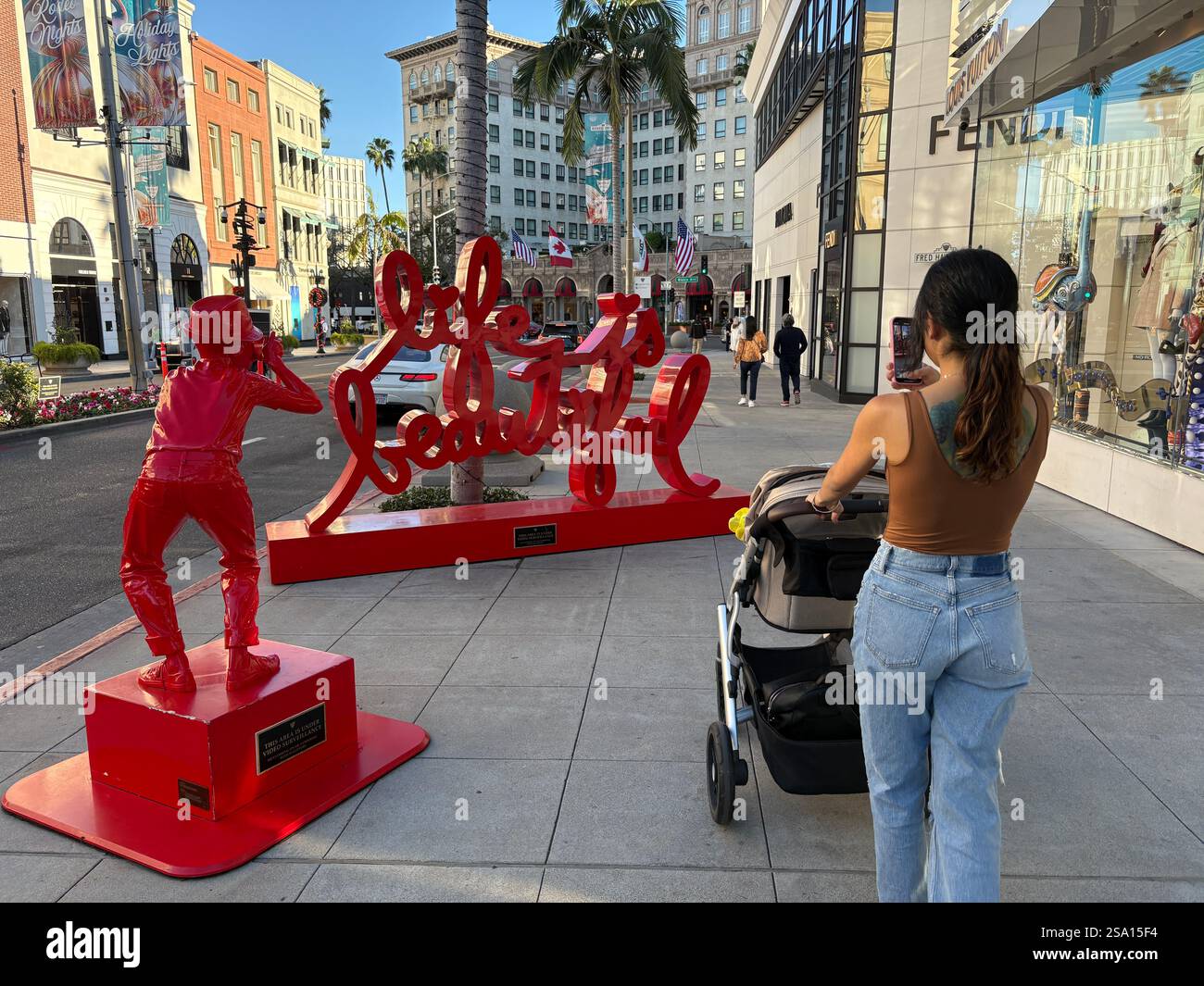 Beautiful Mom on a casual stroll with baby on Rodeo Drive.  Picture taken in November 2024. - Smartphone Captured Stock Image