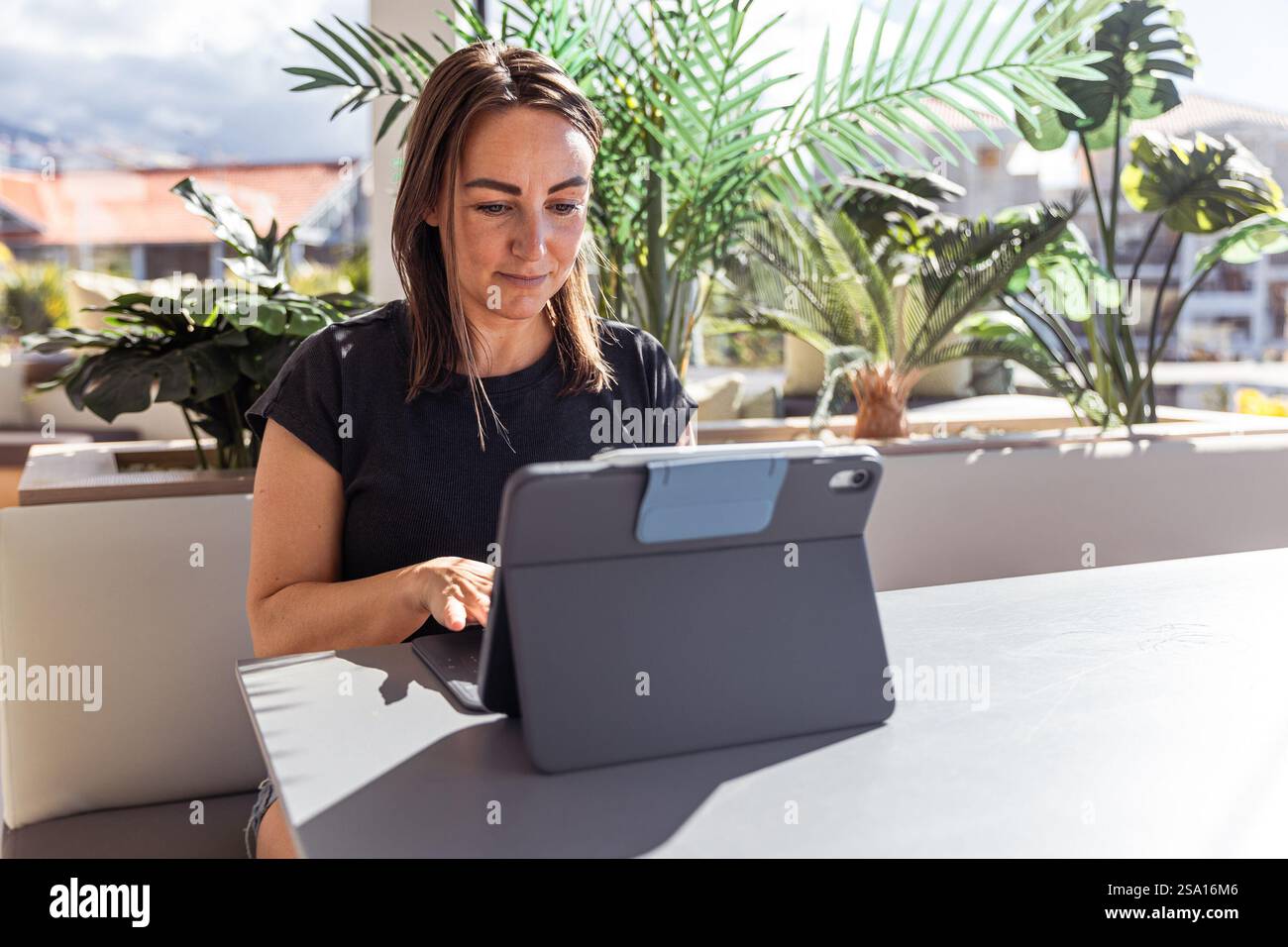 A woman is working using her tablet in the office, photo with copy space. Stock Photo