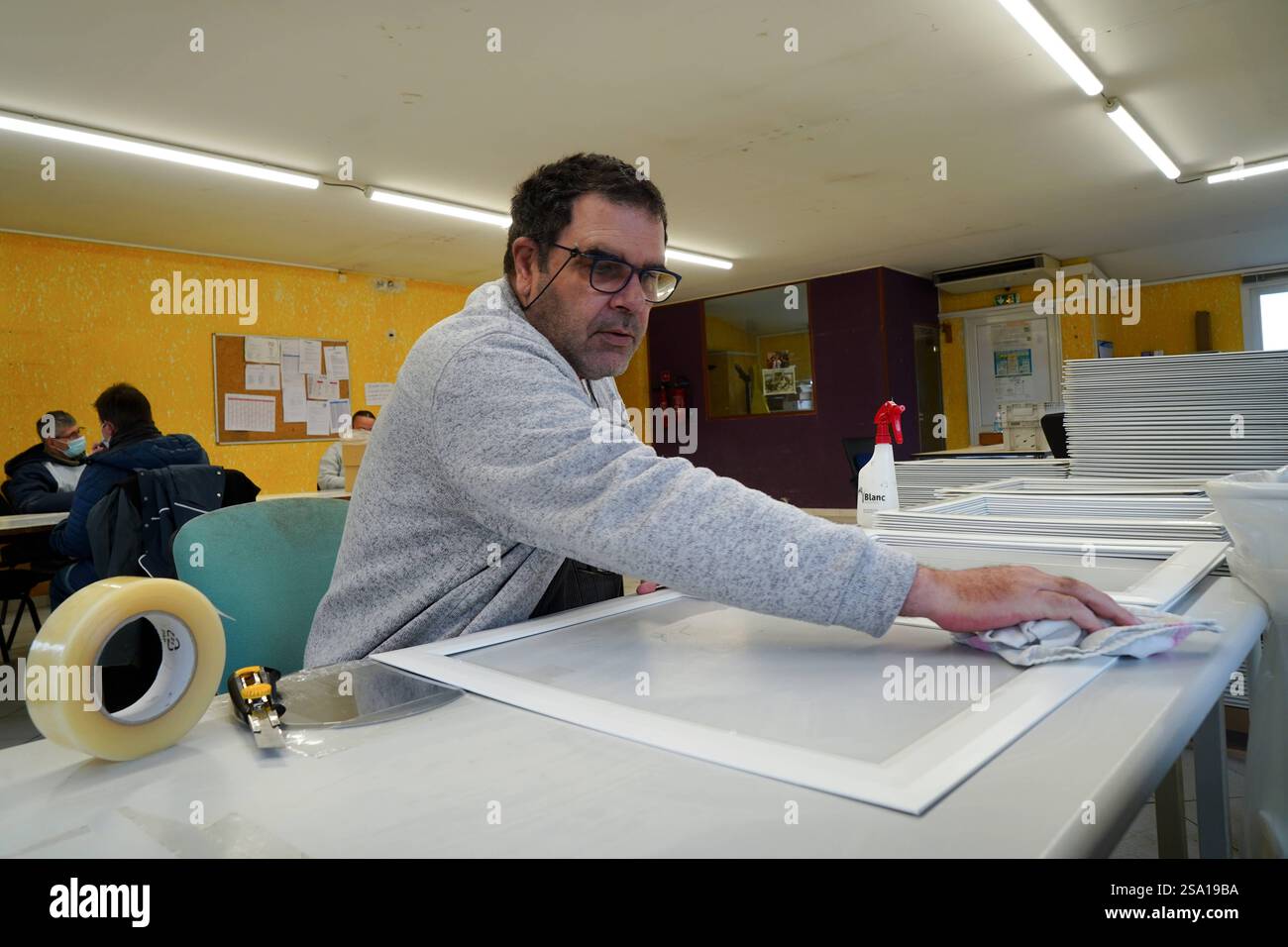 Disabled worker working in the shaping and packaging workshop. Quality ...