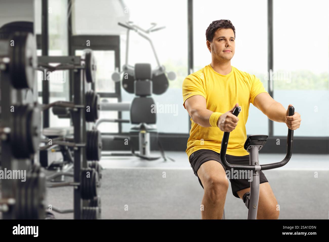 Young man riding an exercise bike at a gym Stock Photo