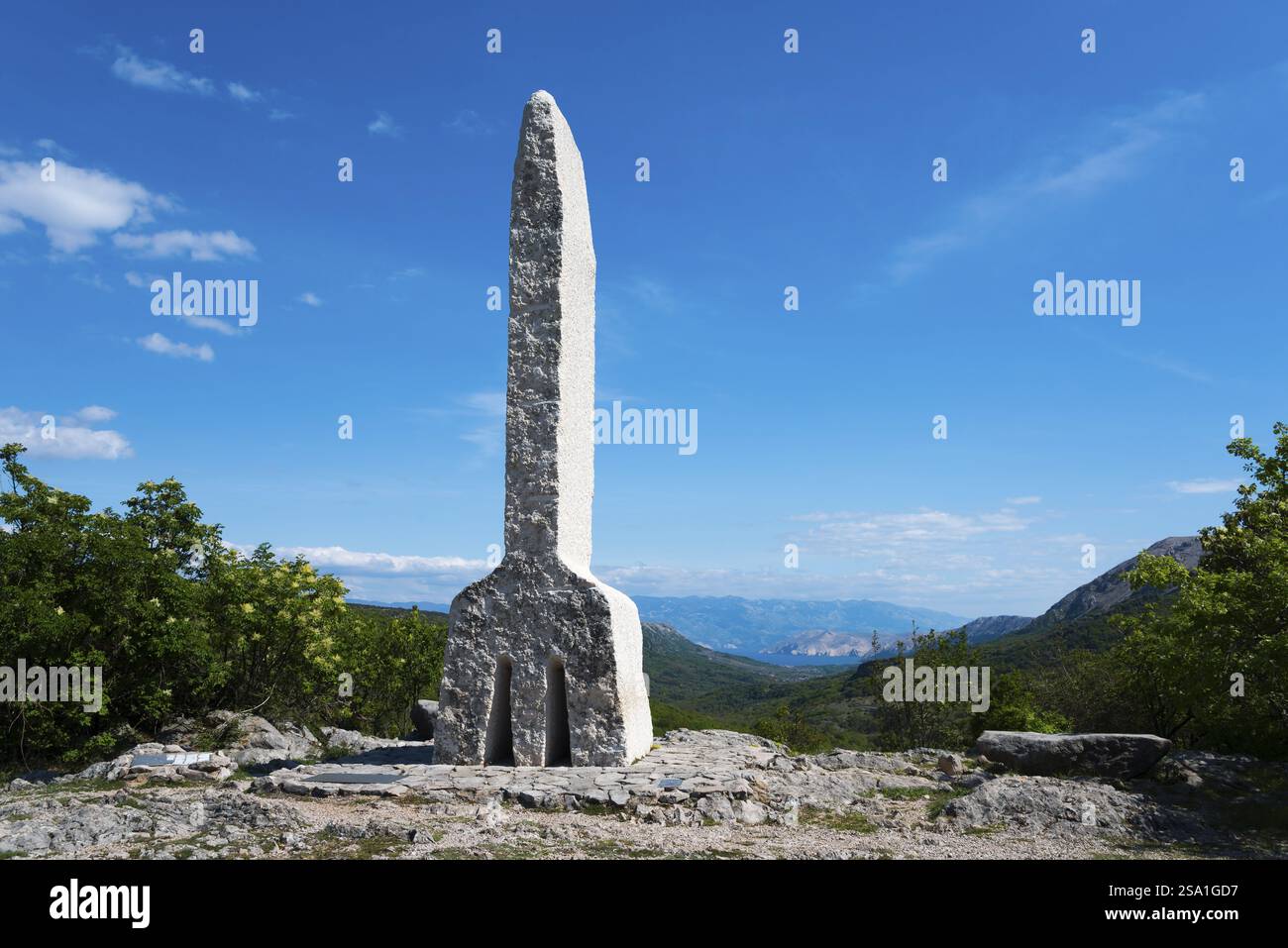 Stone sculpture in front of a mountain backdrop under a clear blue sky on a sunny day, Glagolitsa, the oldest script of the Slavic peoples, monument o Stock Photo