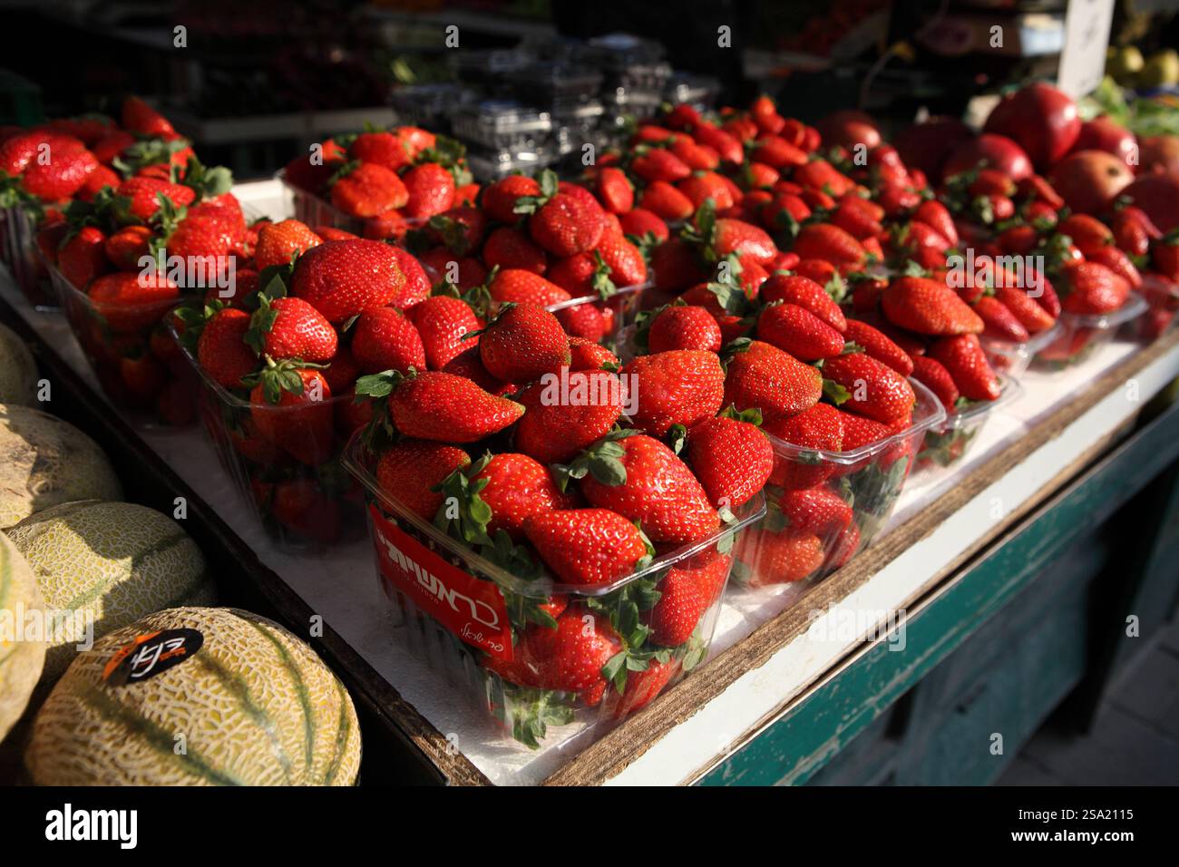 Manchane Strawberries in boxes & melons, fresh produce on sale on a market stall ...