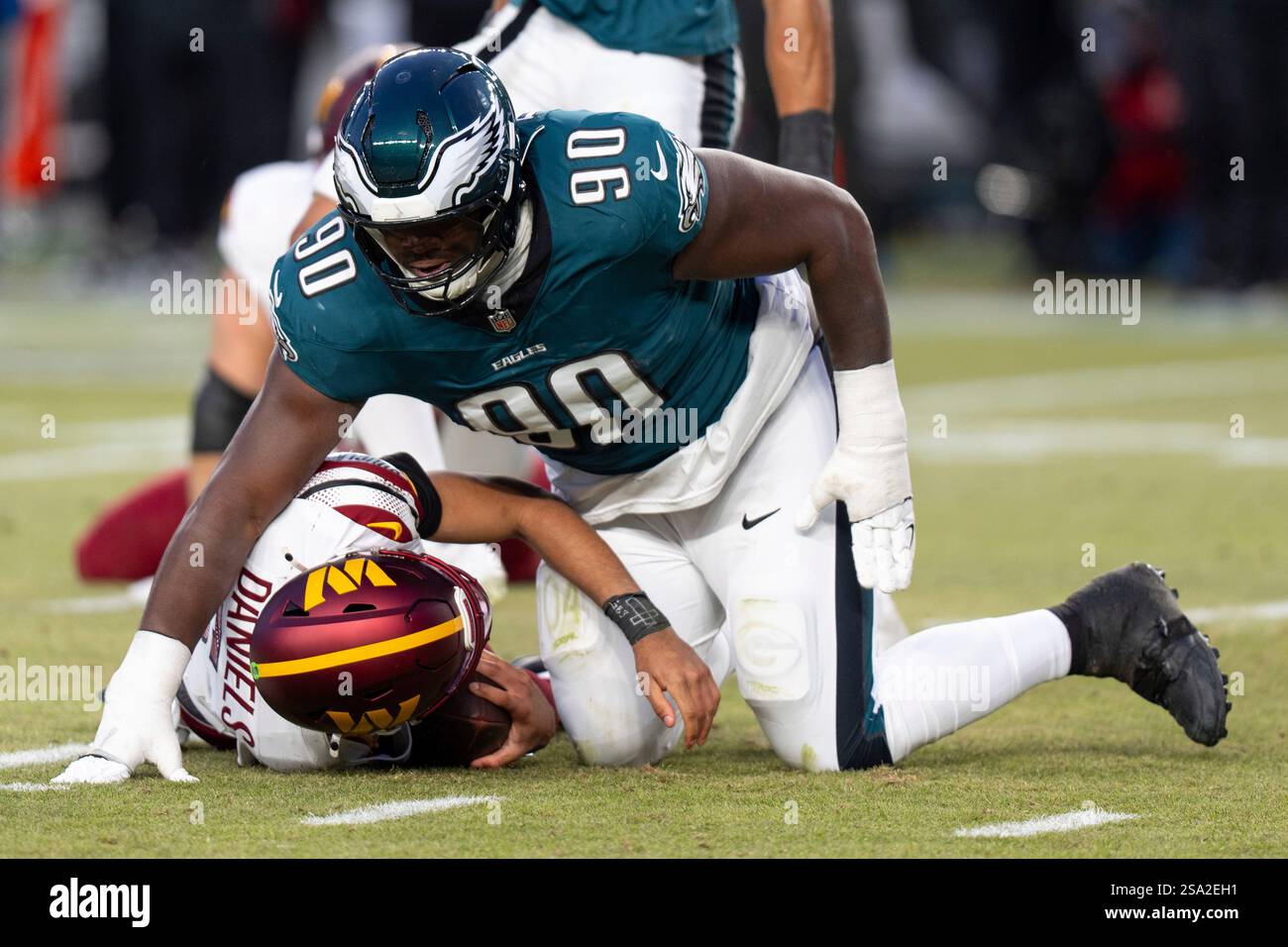 Washington Commanders quarterback Jayden Daniels (5) gets sacked by