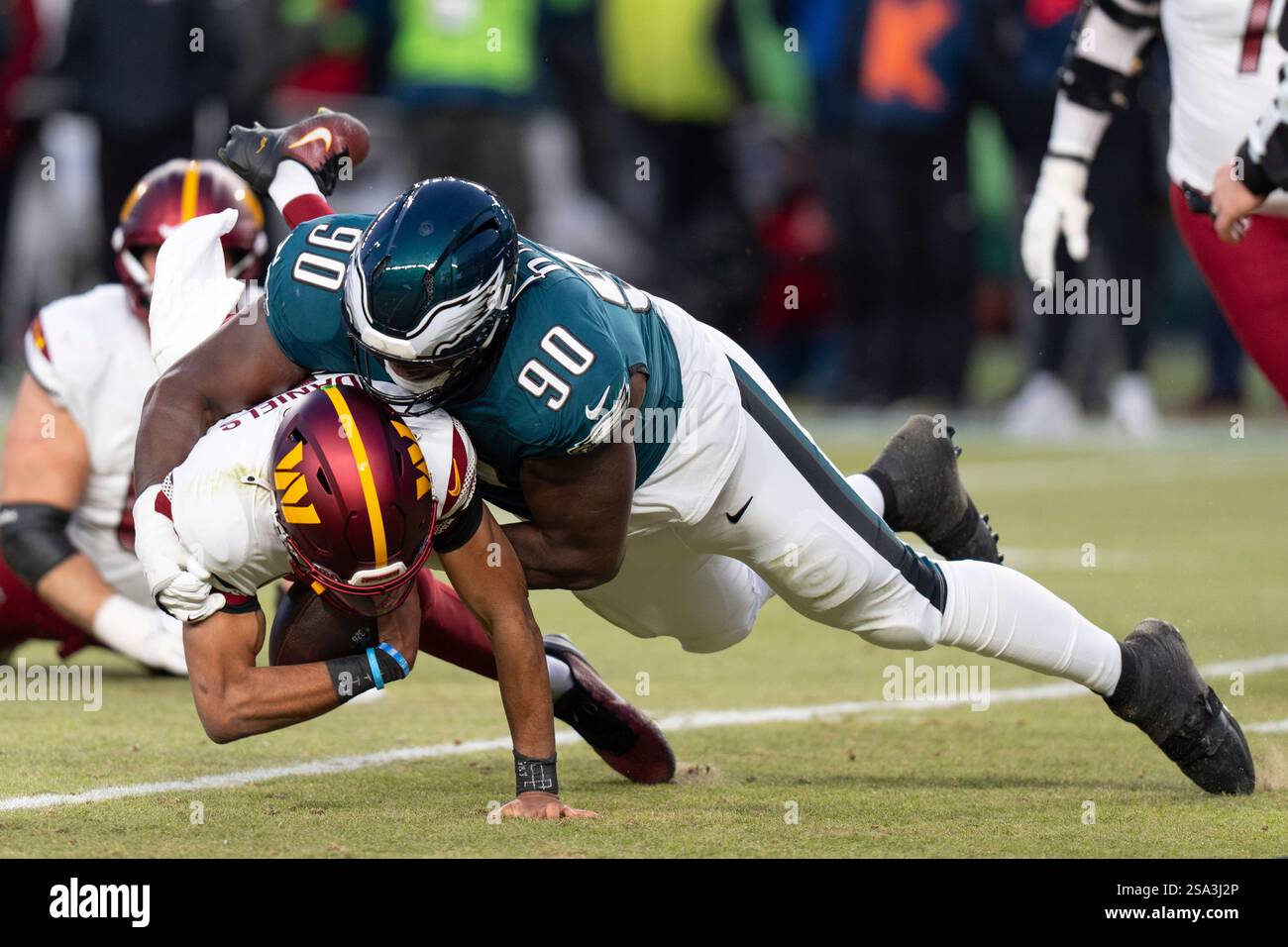 Washington Commanders quarterback Jayden Daniels (5) gets sacked by