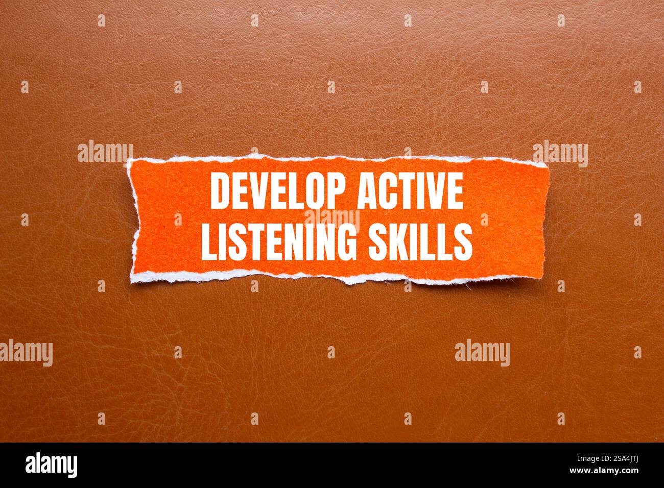 Develop active listening skills message written on ripped orange torn ...
