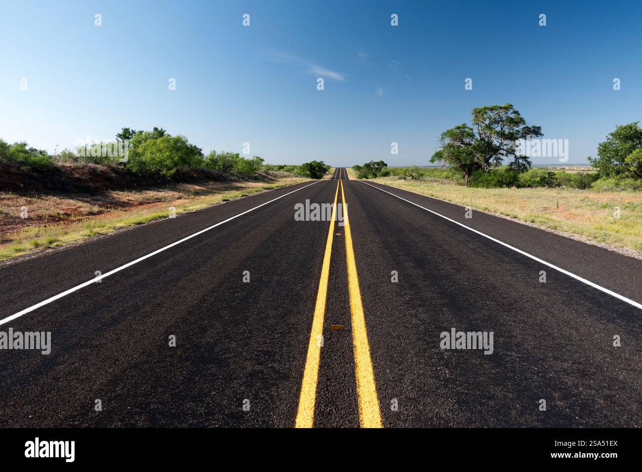 perspective view of a black asphalt highway stretching to the horizon in Donley County, Texas Stock Photo
