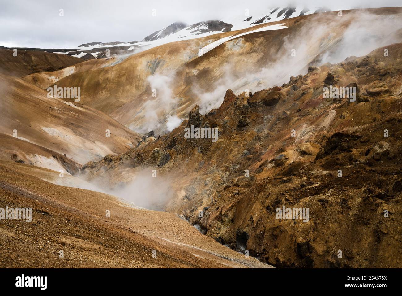 Scenic aerial drone view of a foggy Kerlingarfjoll mountain path amidst desert and snowy terrain in Iceland Stock Photo