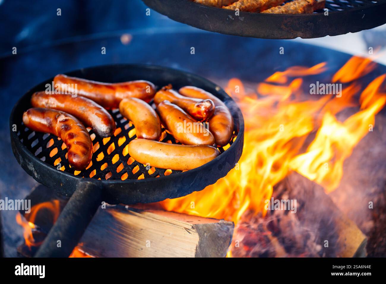 Sausages grilled over open fire outdoors Stock Photo