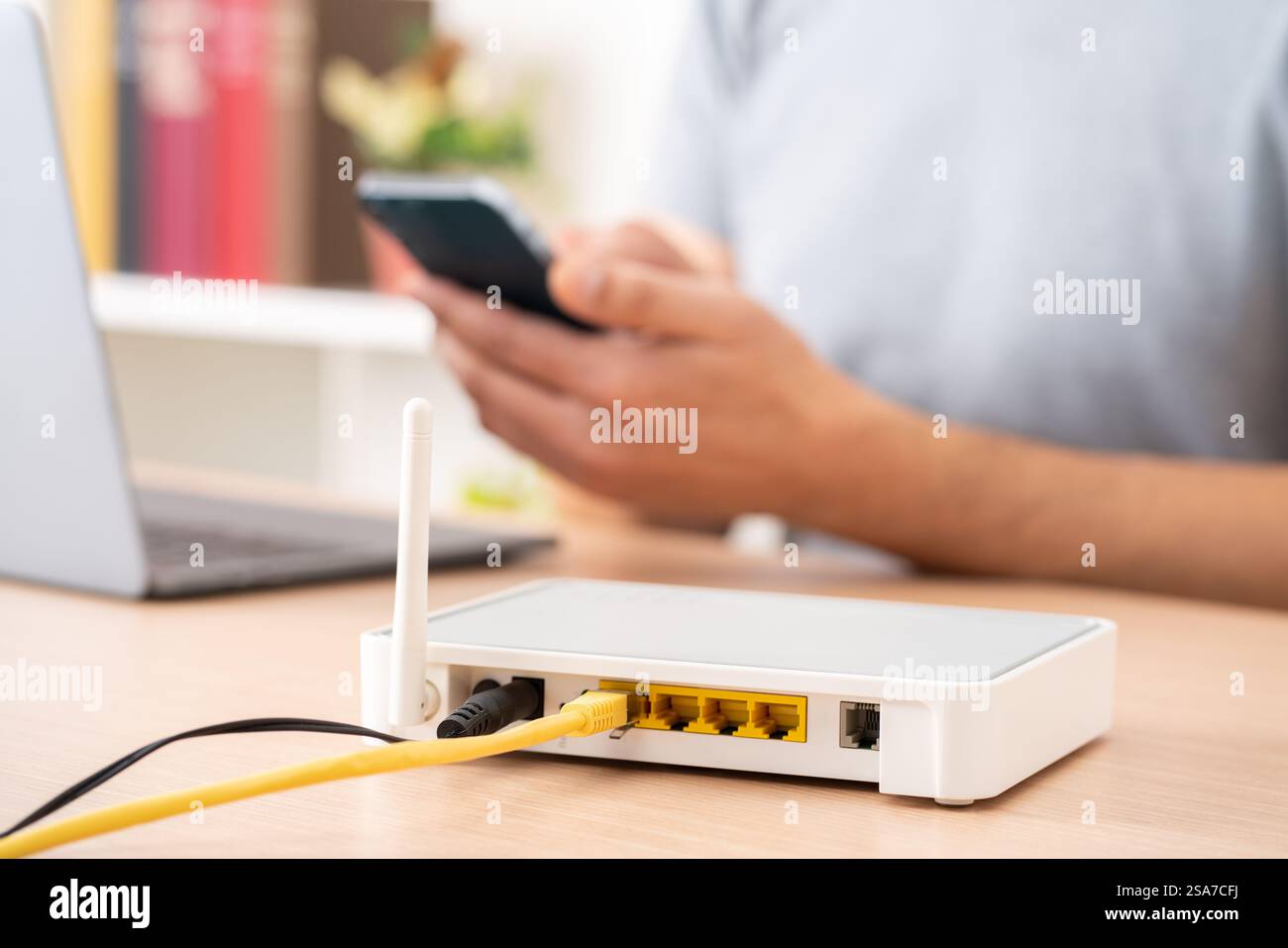 Close up of man hands using multiple devices with broadband router on foreground Stock Photo