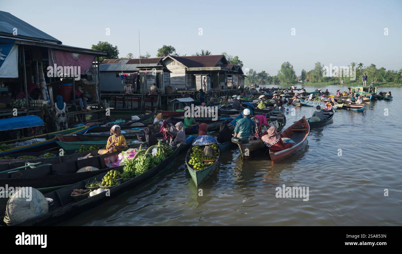 Bustling Scene at Lok Baintan Floating Market in South Kalimantan with Women Vendors Selling Fresh Produce from Colorful Boats Stock Photo