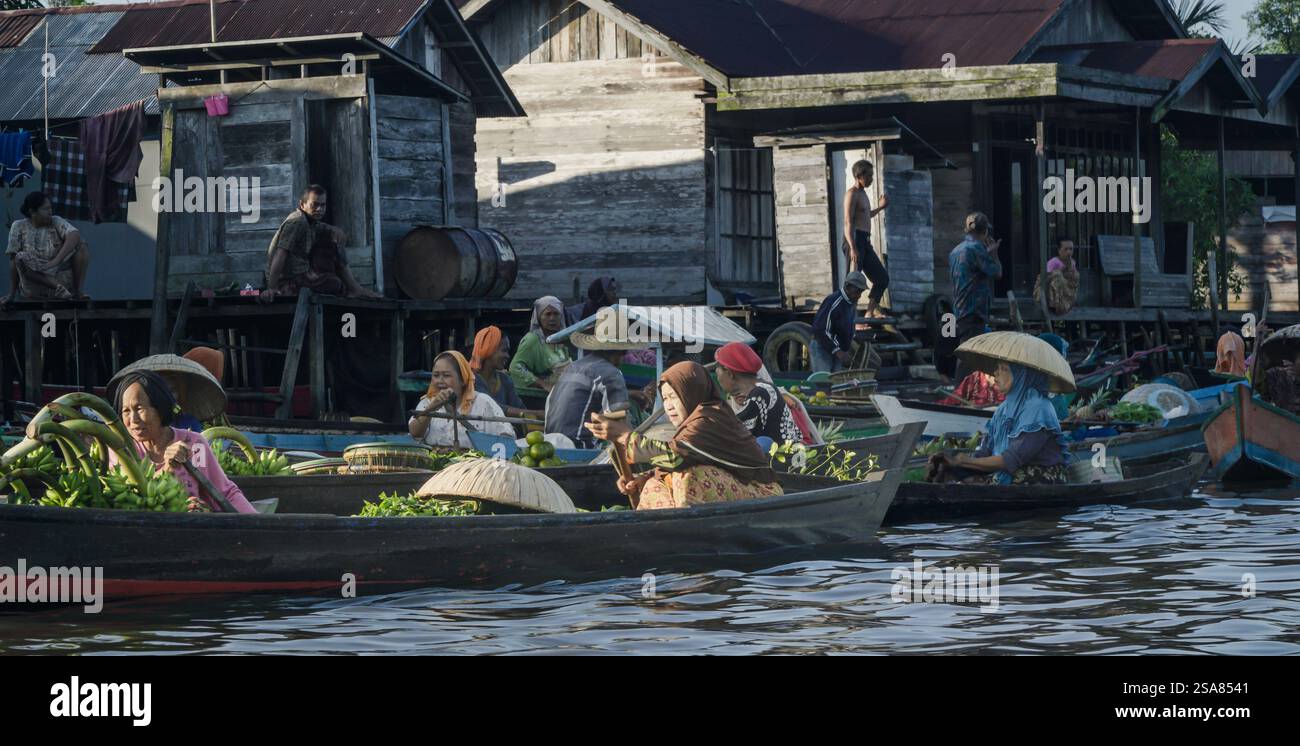Bustling Floating Market in Lok Baintan South Kalimantan with Women Trading Fresh Produce on Traditional Boats Stock Photo