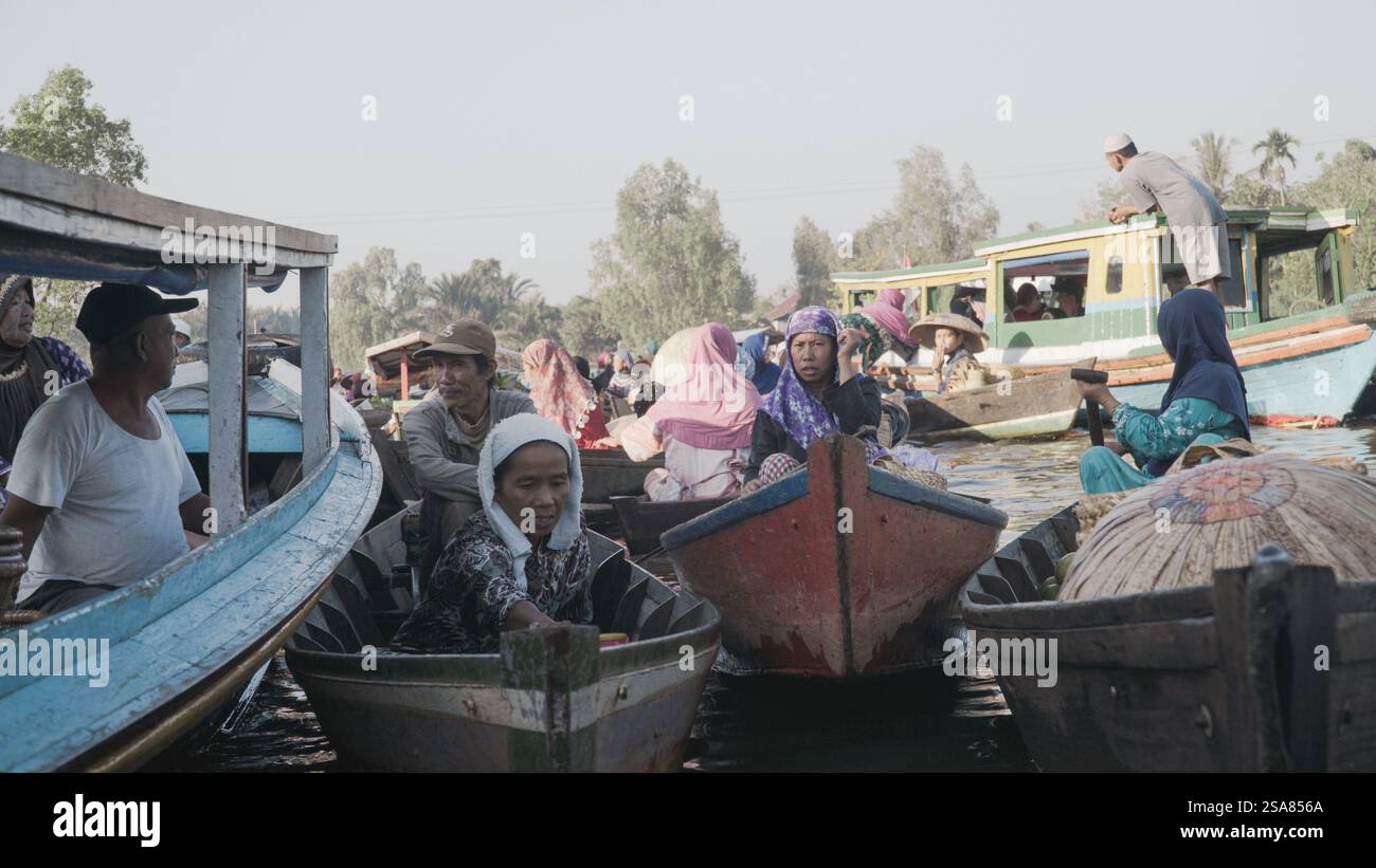 Bustling Floating Market in South Kalimantan with Colorful Boats and Women Bartering Fresh Produce on the River Stock Photo