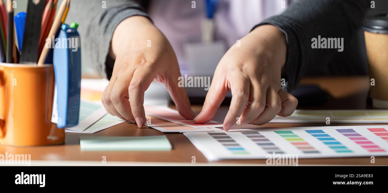 Hands arranging color palettes for graphic design and visual projects ...