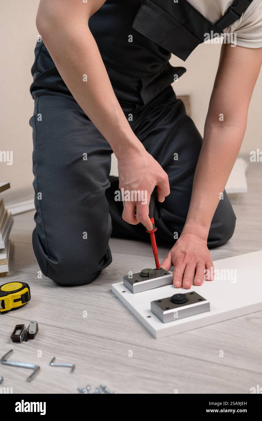 Furniture assembly. The worker installs the legs of the furniture ...