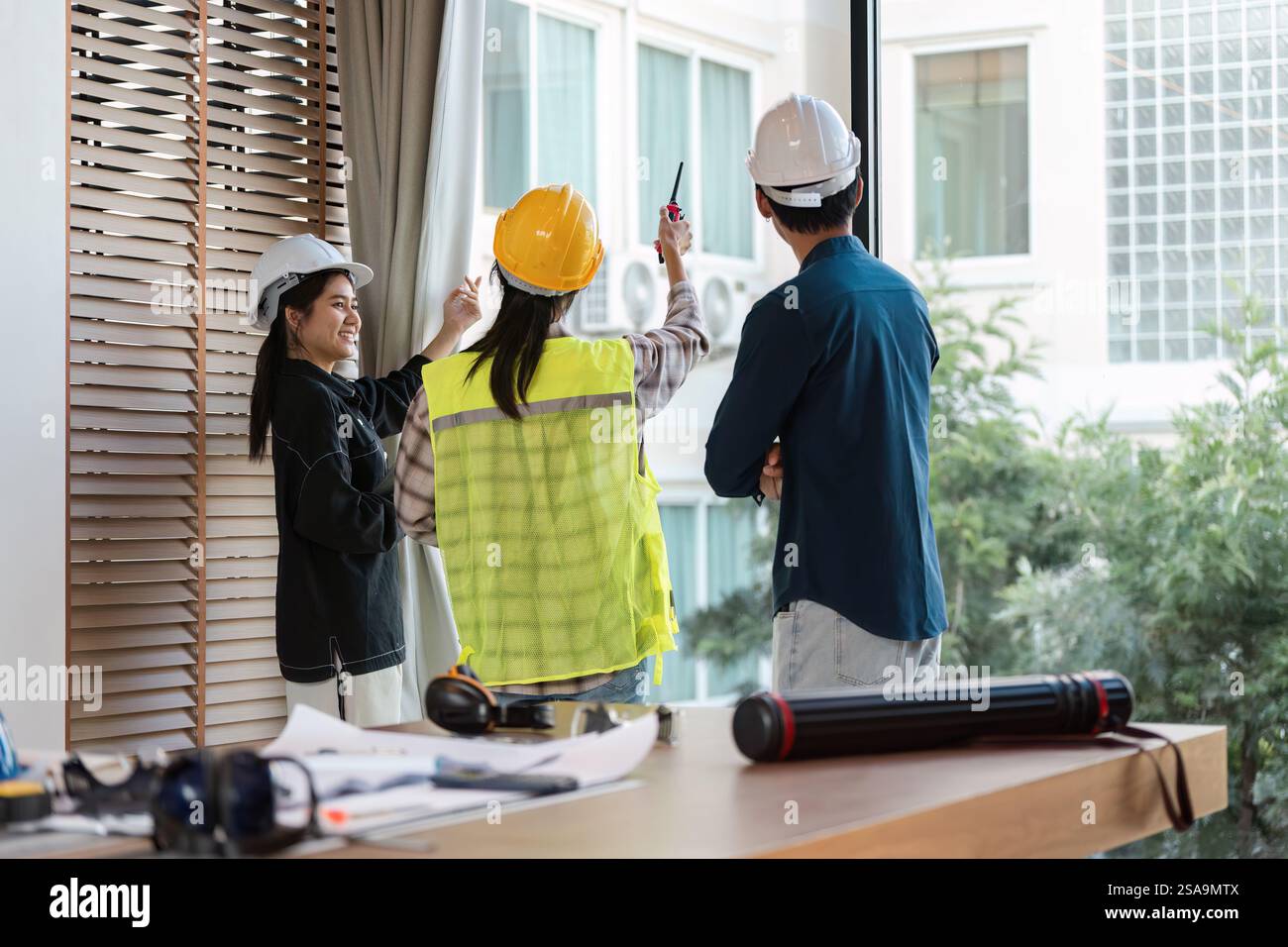 Construction team collaborating on project planning in a modern workspace. Stock Photo