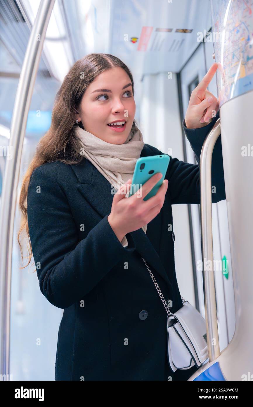 Young Woman Checking Subway Map While Using Smartphone.Vertical Stock Photo