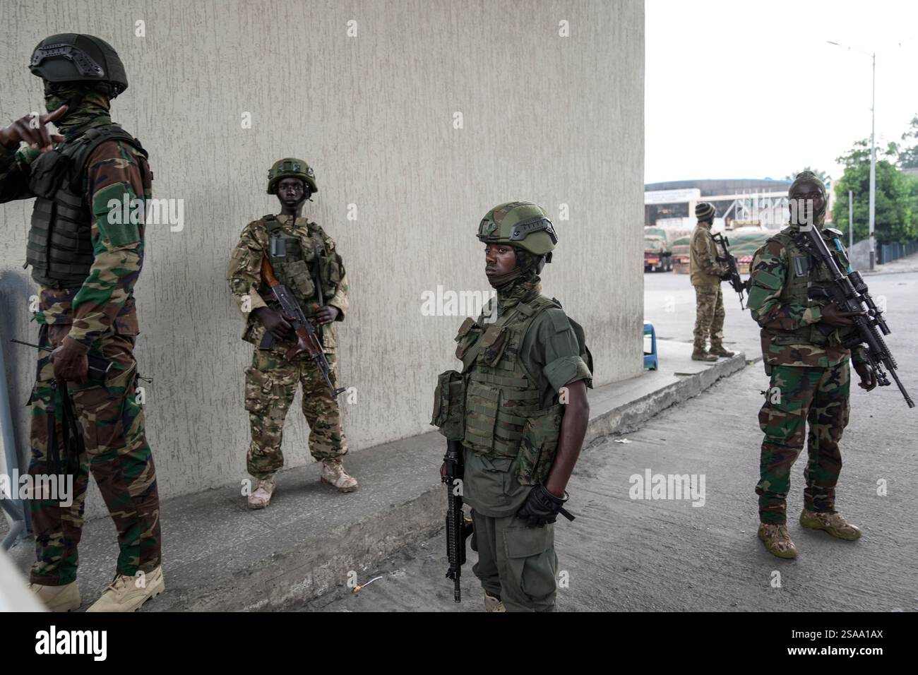 M23 rebels stand guard as they release captured Romanian mercenaries ...