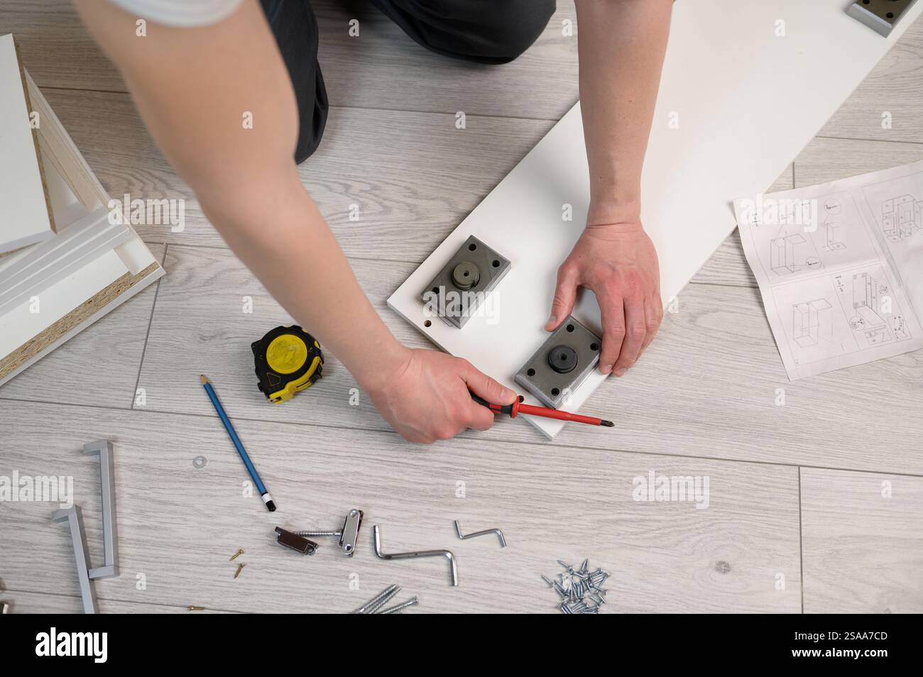 Furniture assembly. The worker installs the legs of the furniture ...