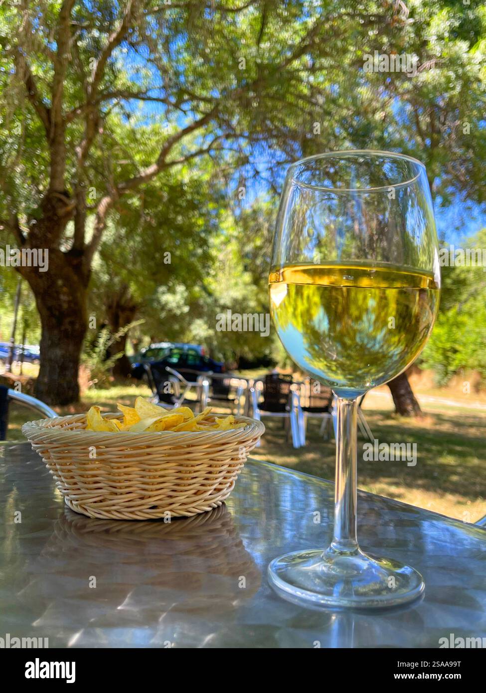Glass of white wine with chips in a terrace. - Smartphone Captured Stock Image