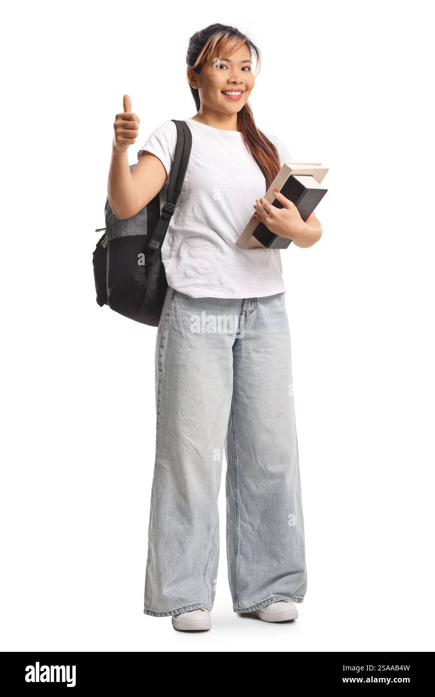 Asian female student holding books and gesturing thumbs up isolated on ...