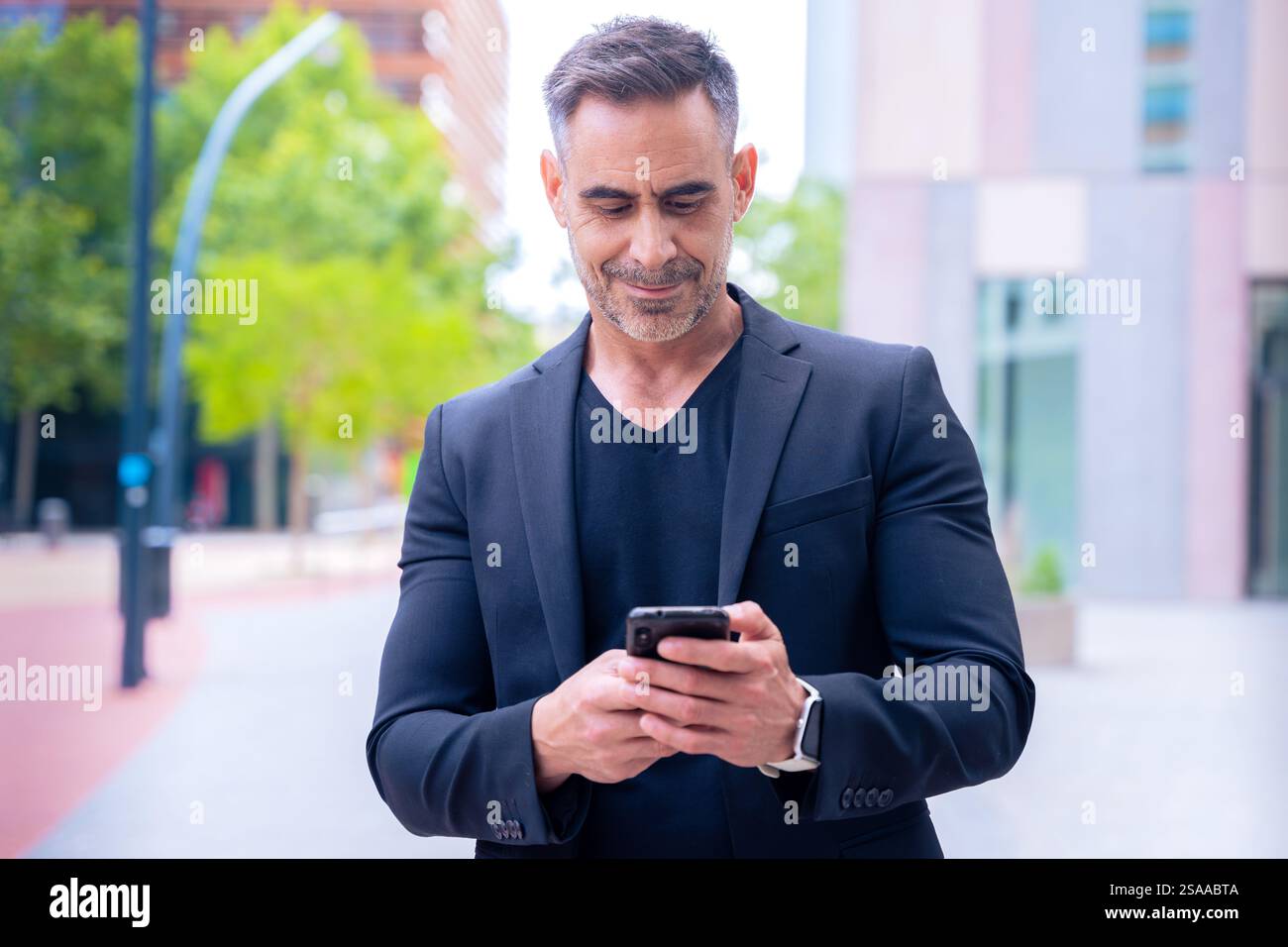 Confident businessman using smartphone outdoors, Stock Photo