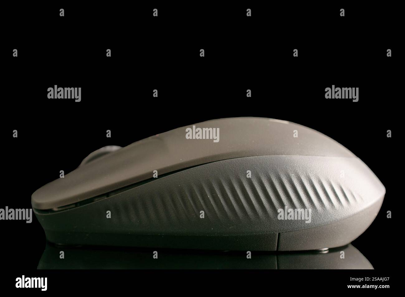 One wireless computer mouse, macro, isolated on a black background. Stock Photo