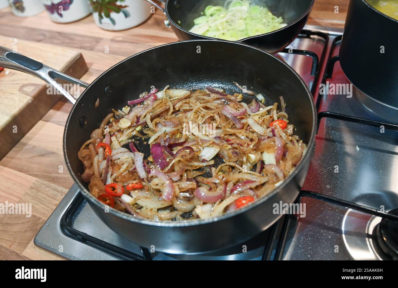 Home cooking making sausage and potato with leeks mash with an onion and chilly gravy casserole : Stock Photo