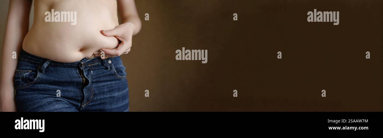 Banner: woman in jeans with bulging fat belly touches fat folds on her ...